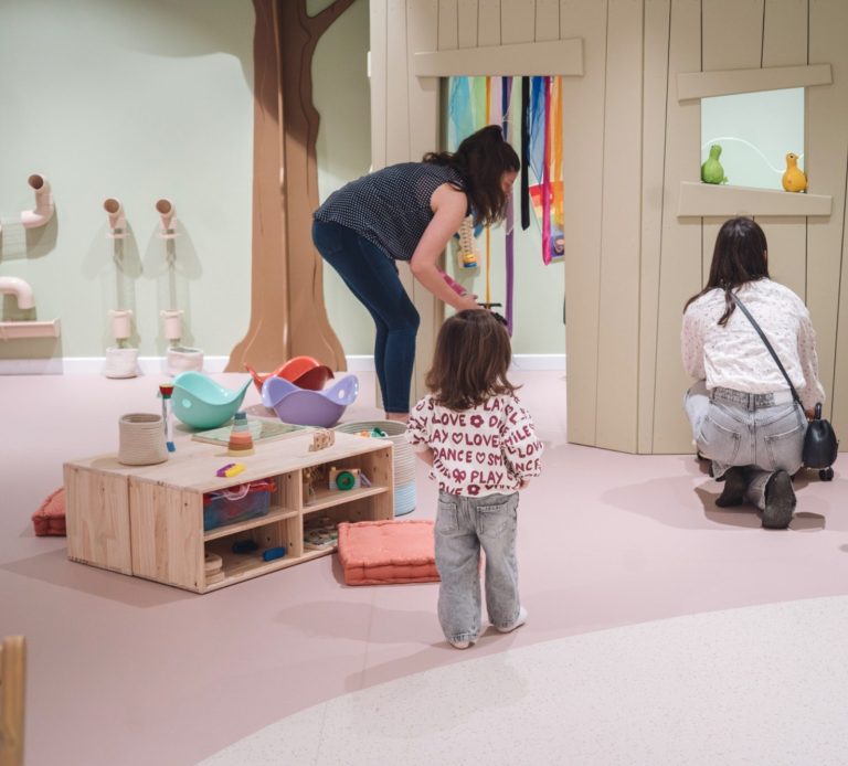 Espace de motricité douce pour tout-petits avec structures en bois, favorisant l’équilibre et l’autonomie.