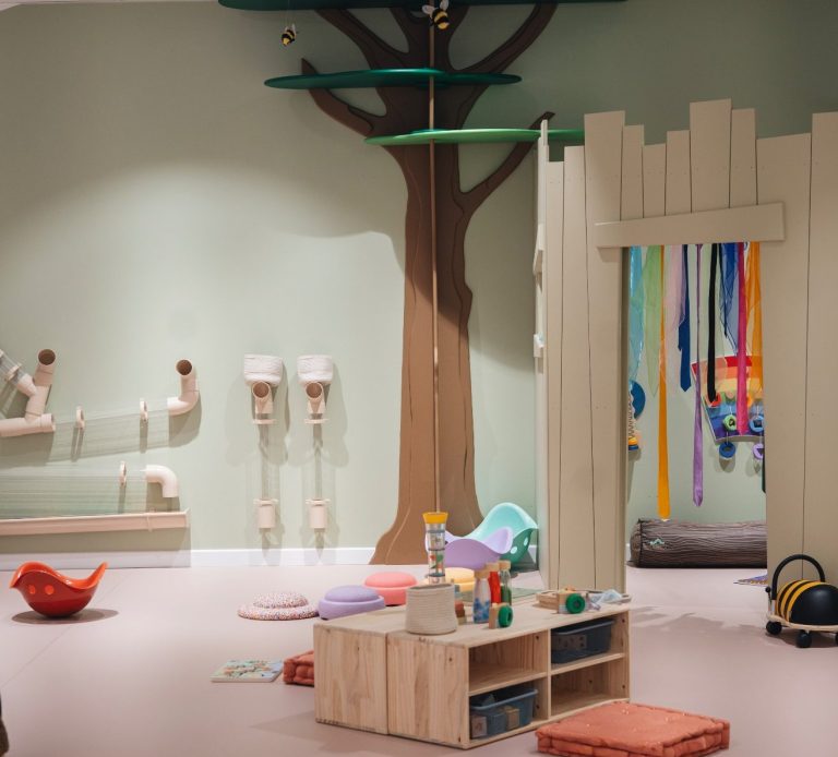 Espace de motricité douce pour tout-petits avec structures en bois, favorisant l’équilibre et l’autonomie.